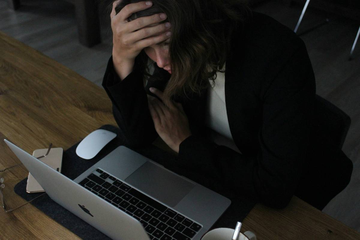 Woman practicing deep breathing at her desk as a mental stress management technique